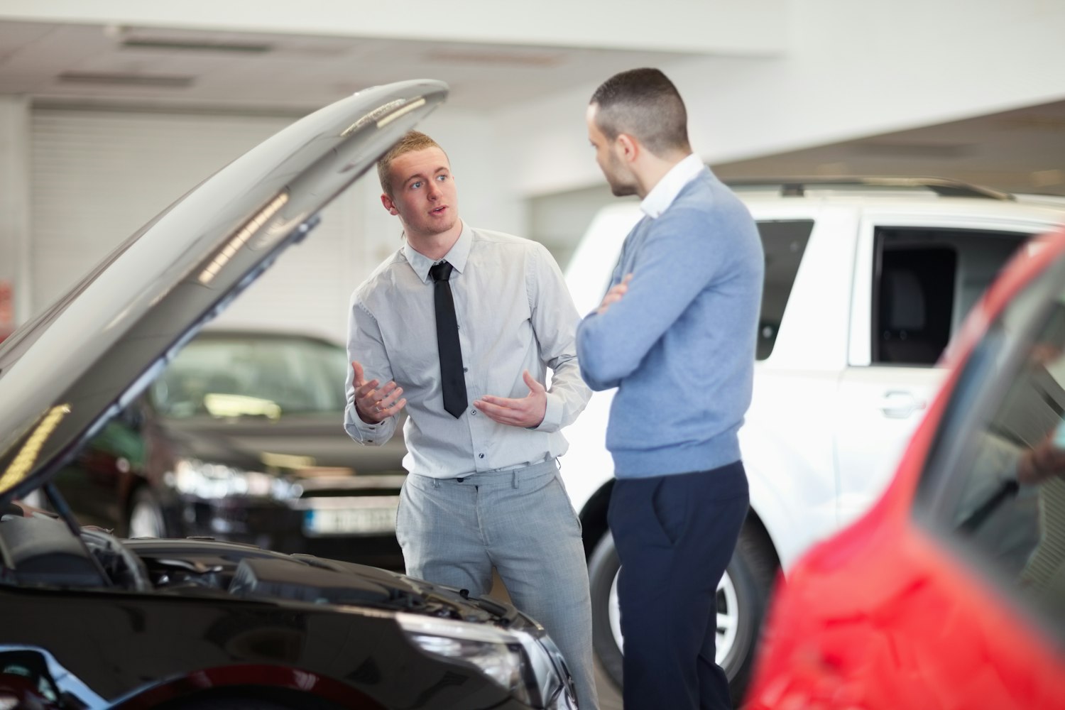 Due persone che discutono in un salone d'automobili