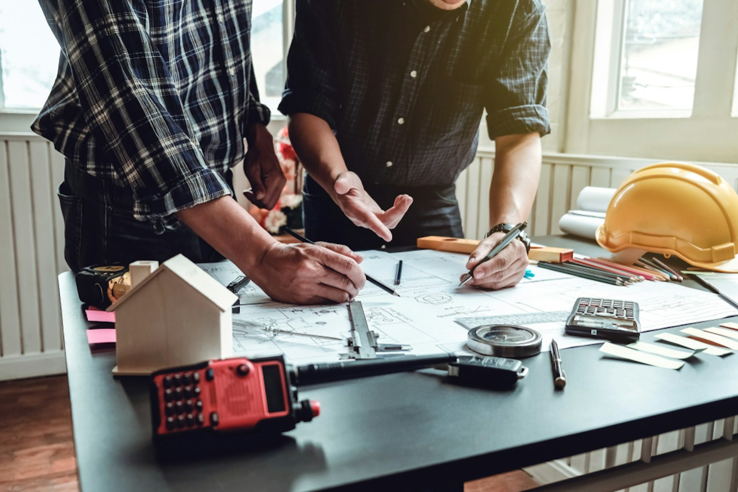 Due ingegneri lavorano insieme ad un progetto su una scrivania