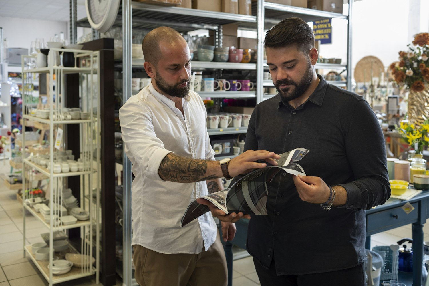 Il titolare di MR Stock mostra un catalogo a un cliente