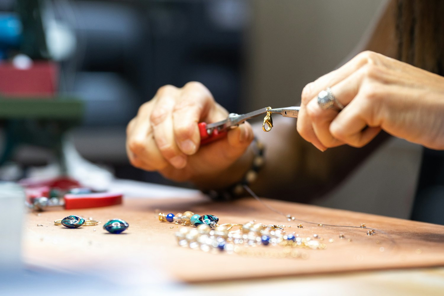 Mani che lavorano gioielli in vetro di Murano