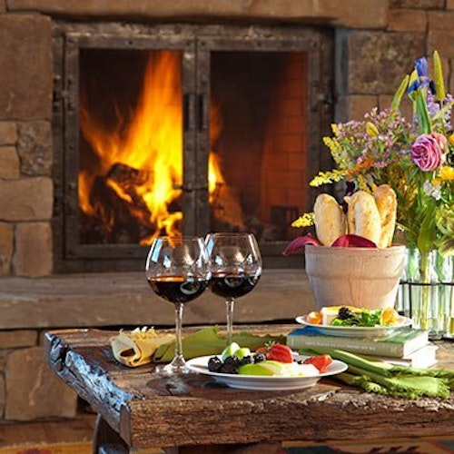 Wine glasses in front of a fireplace