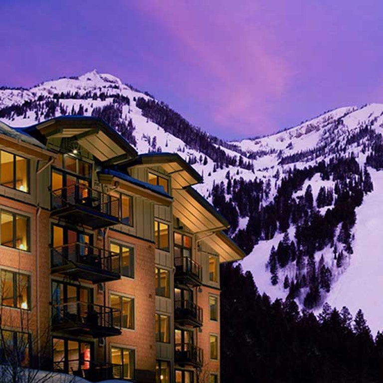 Hotel lit up with Jackson Hole Resort Ski area in background