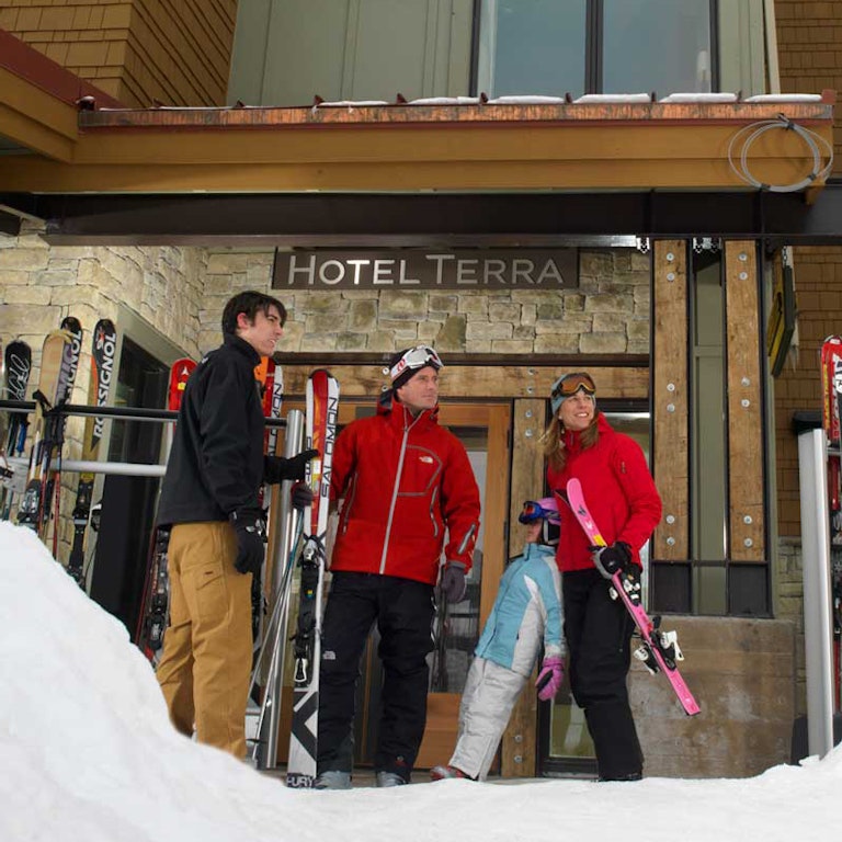 Family renting skis from ski valet outside of Hotel Terra