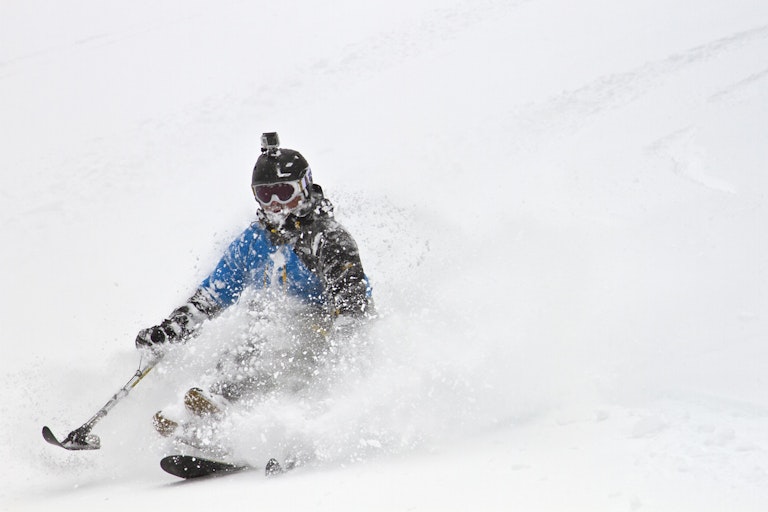 Adaptive skier in powder