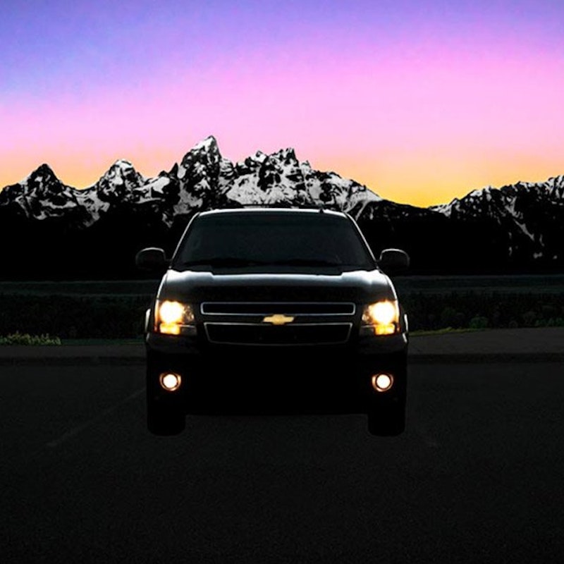 Parked taxi car with the Tetons in the background at sunset