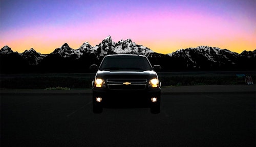 Parked taxi car with the Tetons in the background at sunset