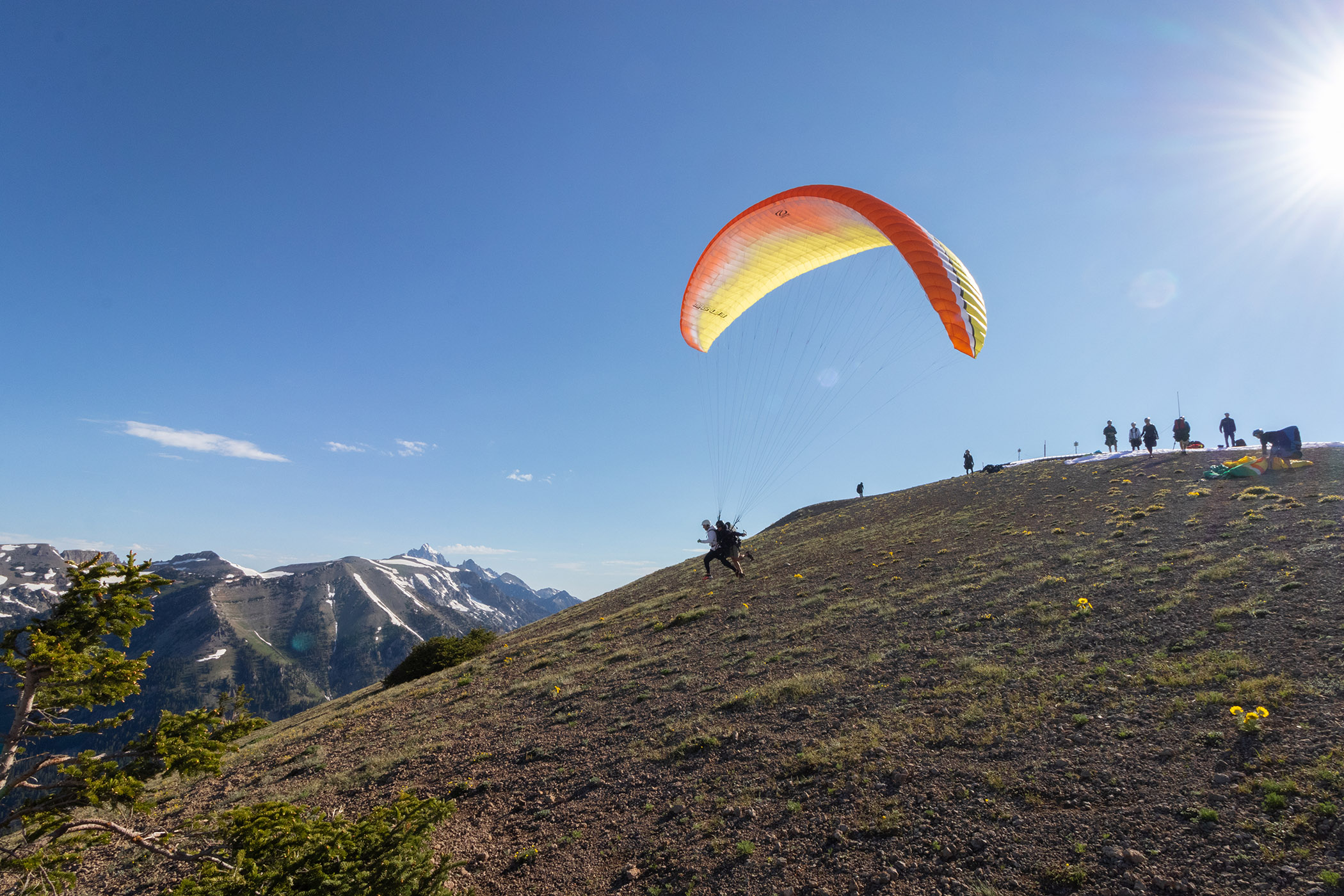 Paragliding off of the mountain on a sunny day