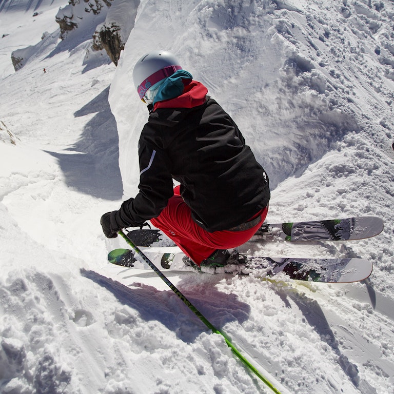 Skier dropping into Corbet's Couloir on a powder day