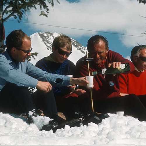 Lifestyle shot of a group pouring a glass of beer in the sixties on the resort