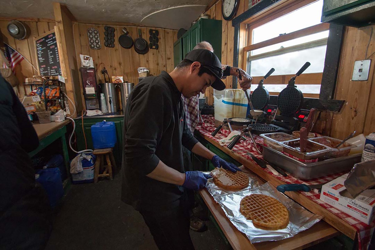 Employee preparing made to order waffles