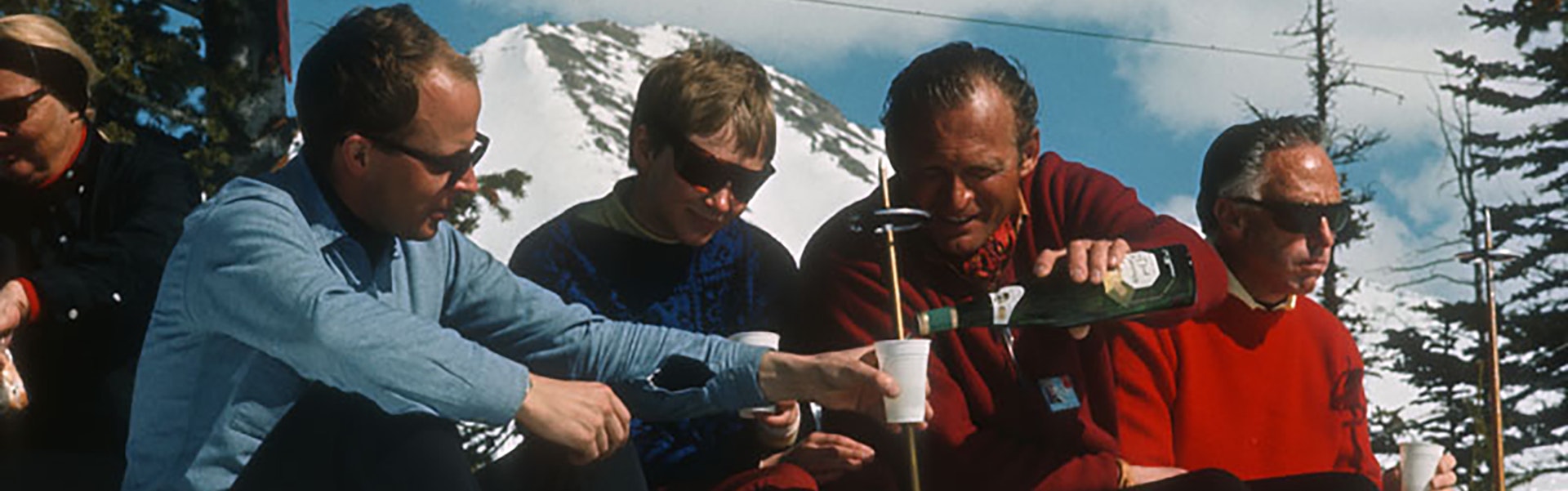 Group of men sharing a beer on the slopes in the 60s