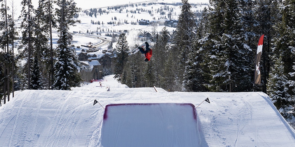 Snowboarder doing a flip off of a jump in the Terrain Park