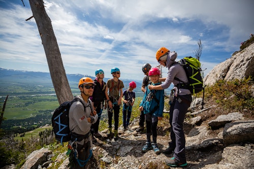 Guides getting a group fitted with gear for the Via Ferrata