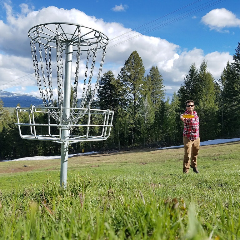 Man throwing a disc in the Disc Golf course