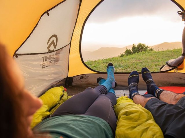 Campers laying in tent wearing Smartwool socks
