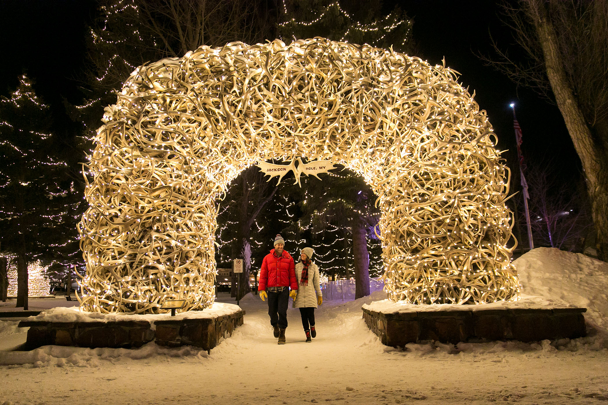 Couple walking under the antler arches on Town Square