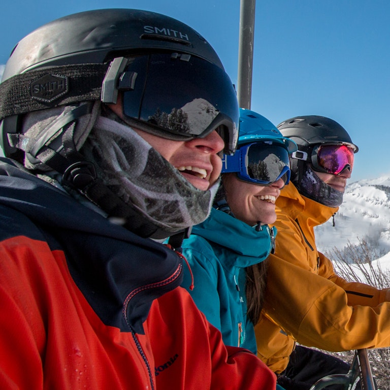 Employees smiling on a chairlift