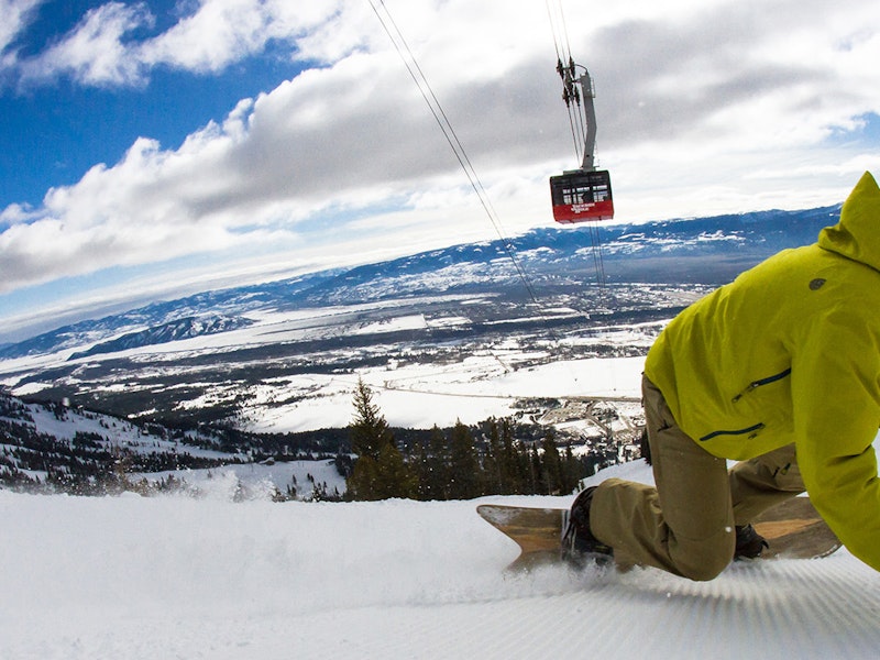 Snowboarder ripping under the Tram