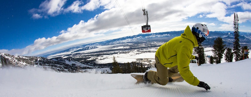 Snowboarder ripping under the Tram