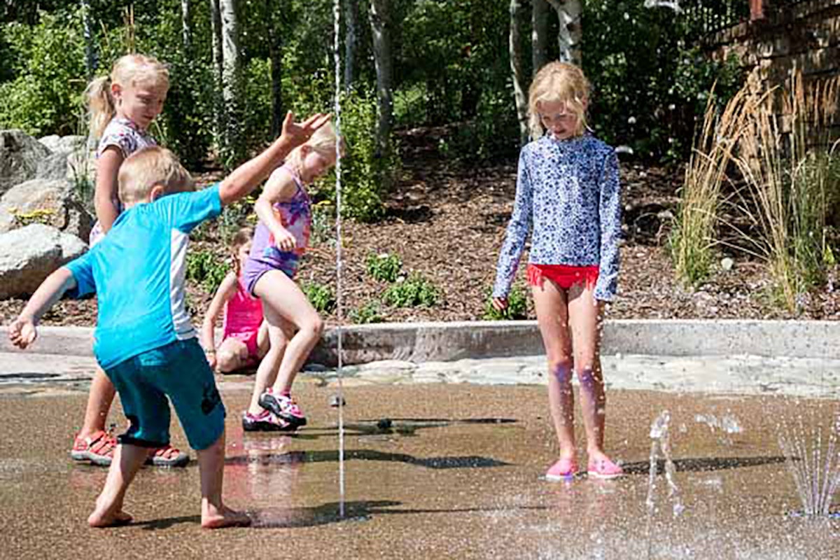 Kids playing in pop jets on a nice summer day