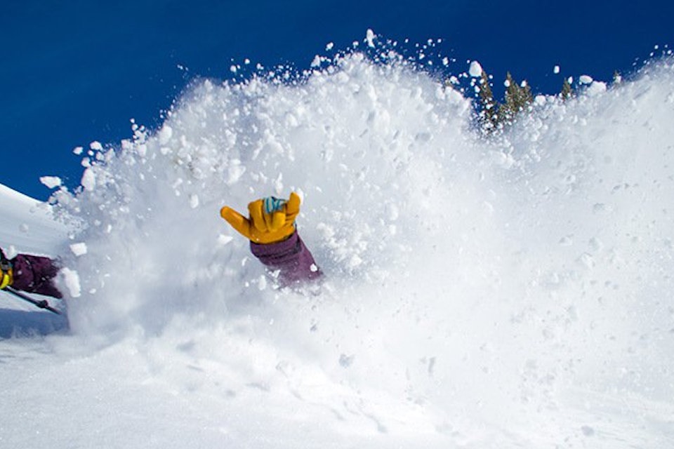 Glove giving the hang loose through a blast of snow