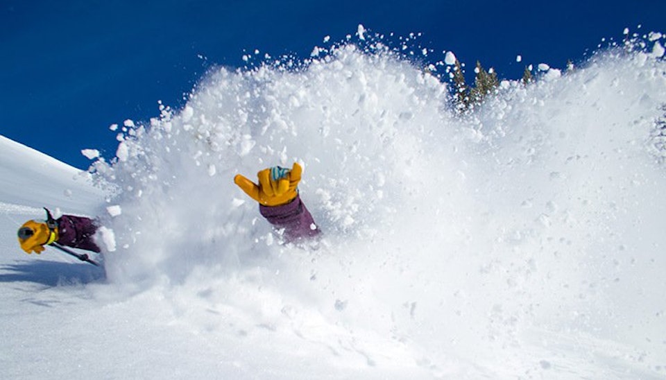 Glove giving the hang loose through a blast of snow