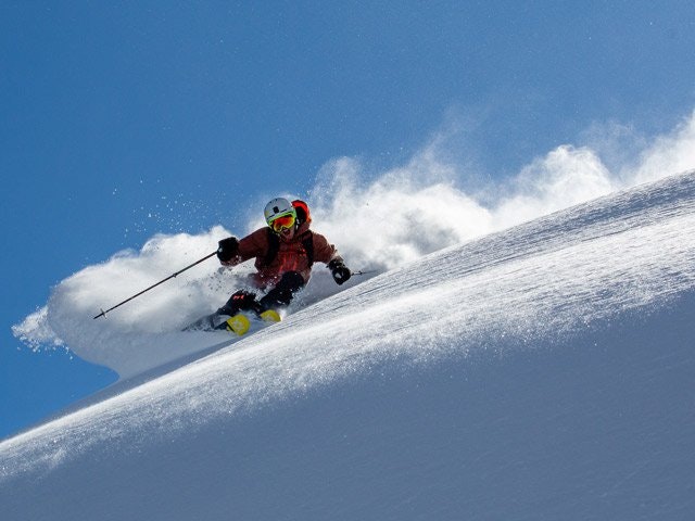 Skiing down a open powder slope