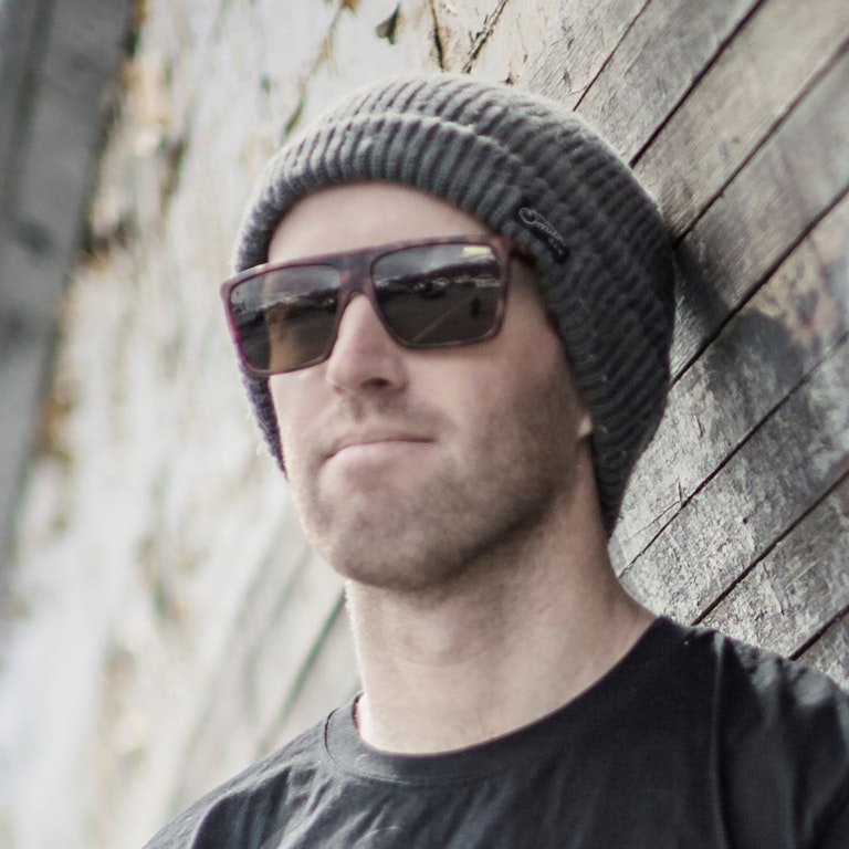 Griffin Post standing against a wall in sunglasses