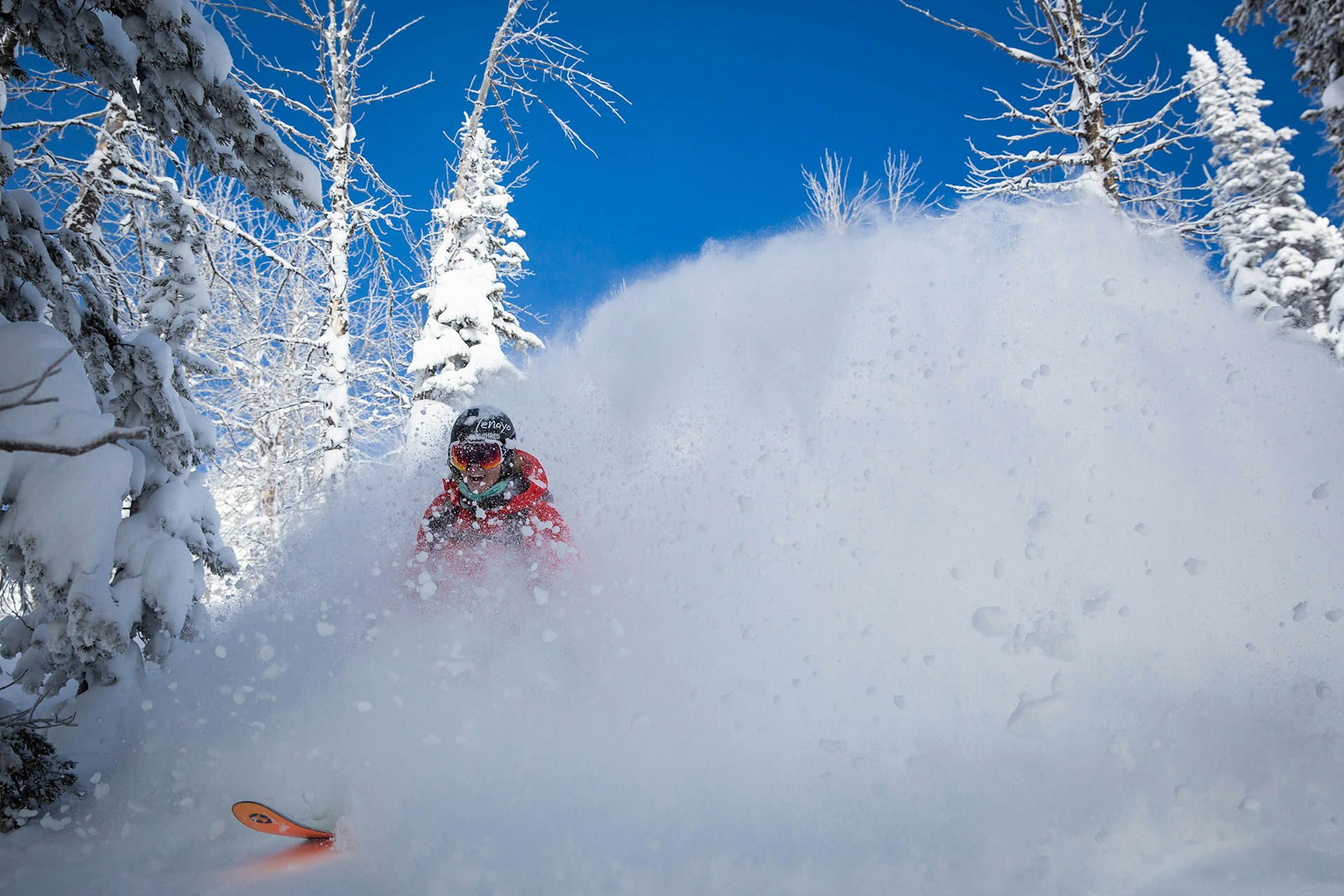 Girl smiling while blasting through a cloud of pow