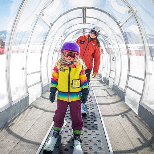 On magic carpet lift teaching kids ski lesson