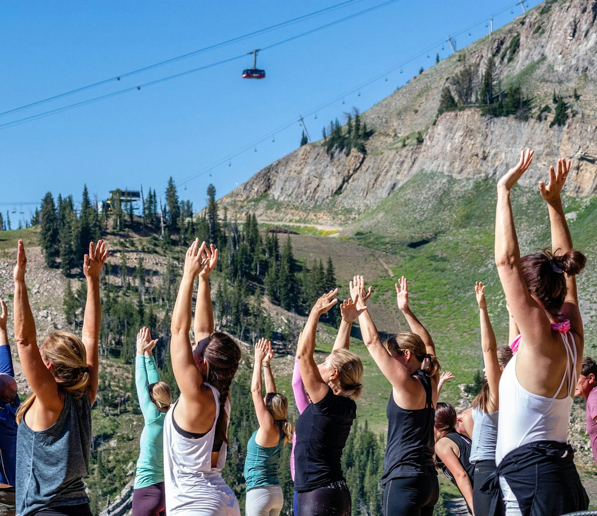 women doing yoga outside with the Tram in the background