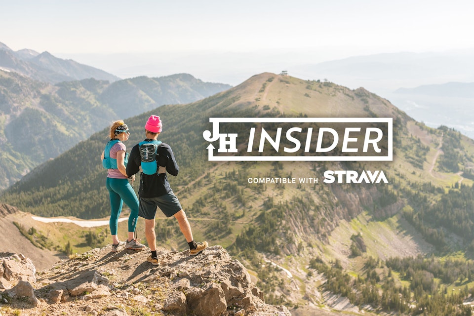 Two hikers taking in the view with the JH Insider logo