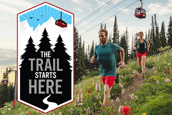 Man and woman trail running with The Trail Starts Here logo