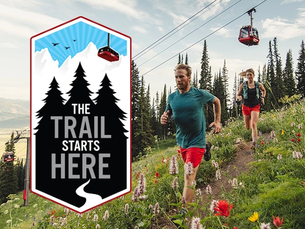 Man and woman trail running with The Trail Starts Here logo