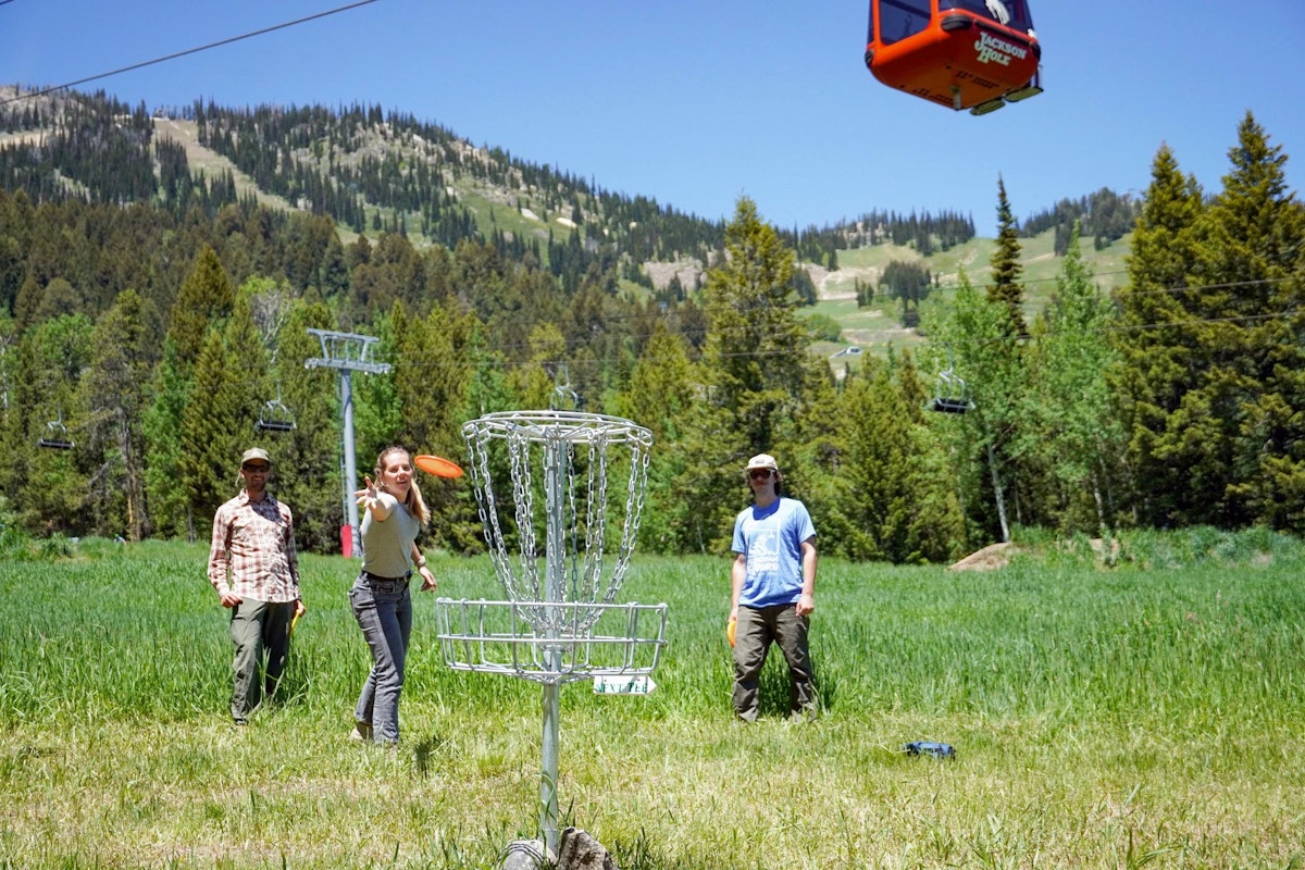 Three people playing a round of disc golf