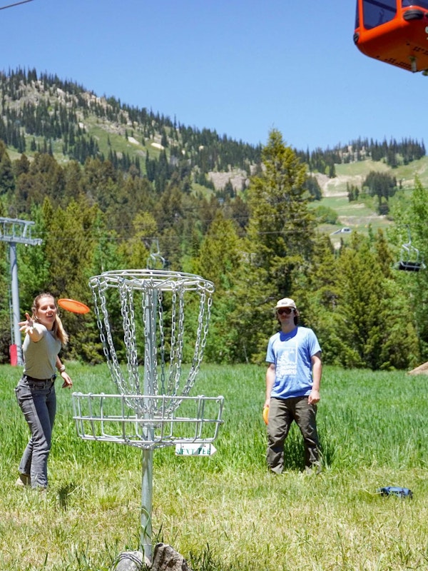 Three people playing a round of disc golf