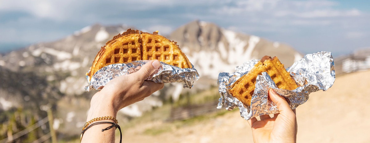 Holding waffles up outside Corbet's Cabin