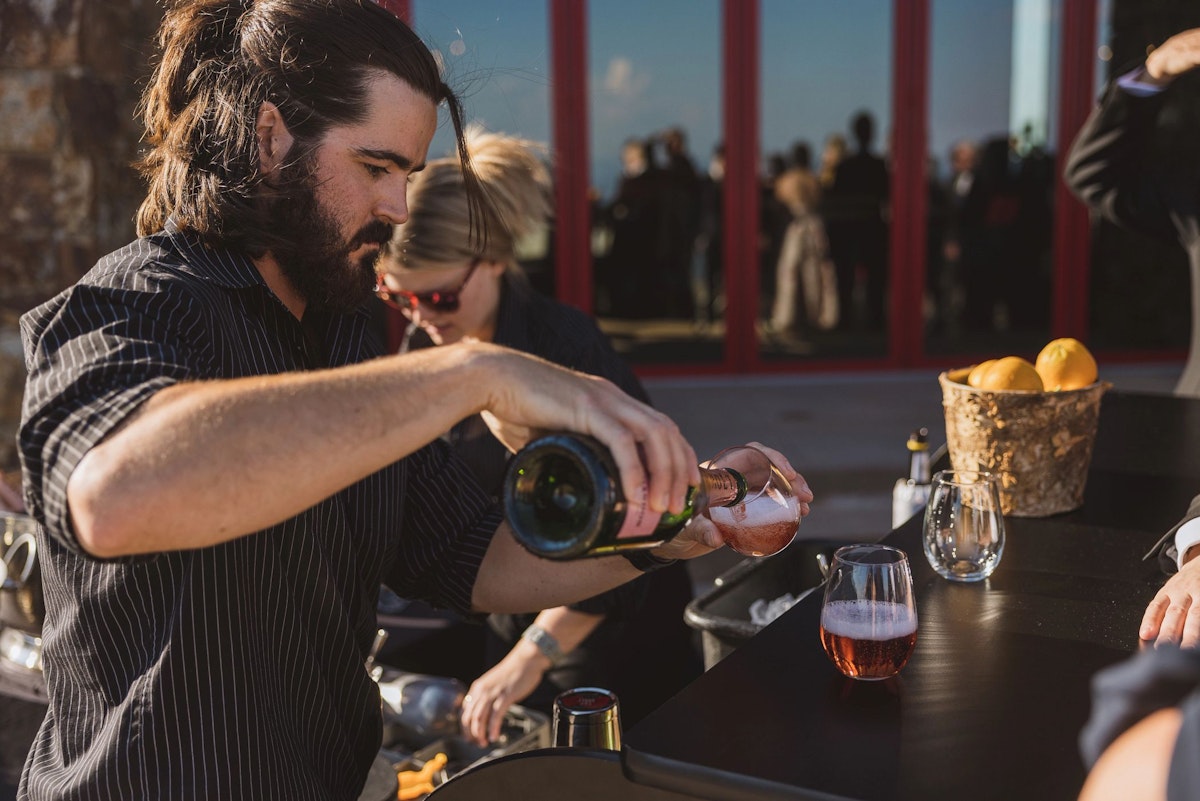 Bartender pouring wine at wedding on The Deck