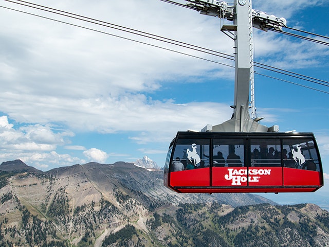 The Aerial Tram soaring through the air in summer with The Grand in the background