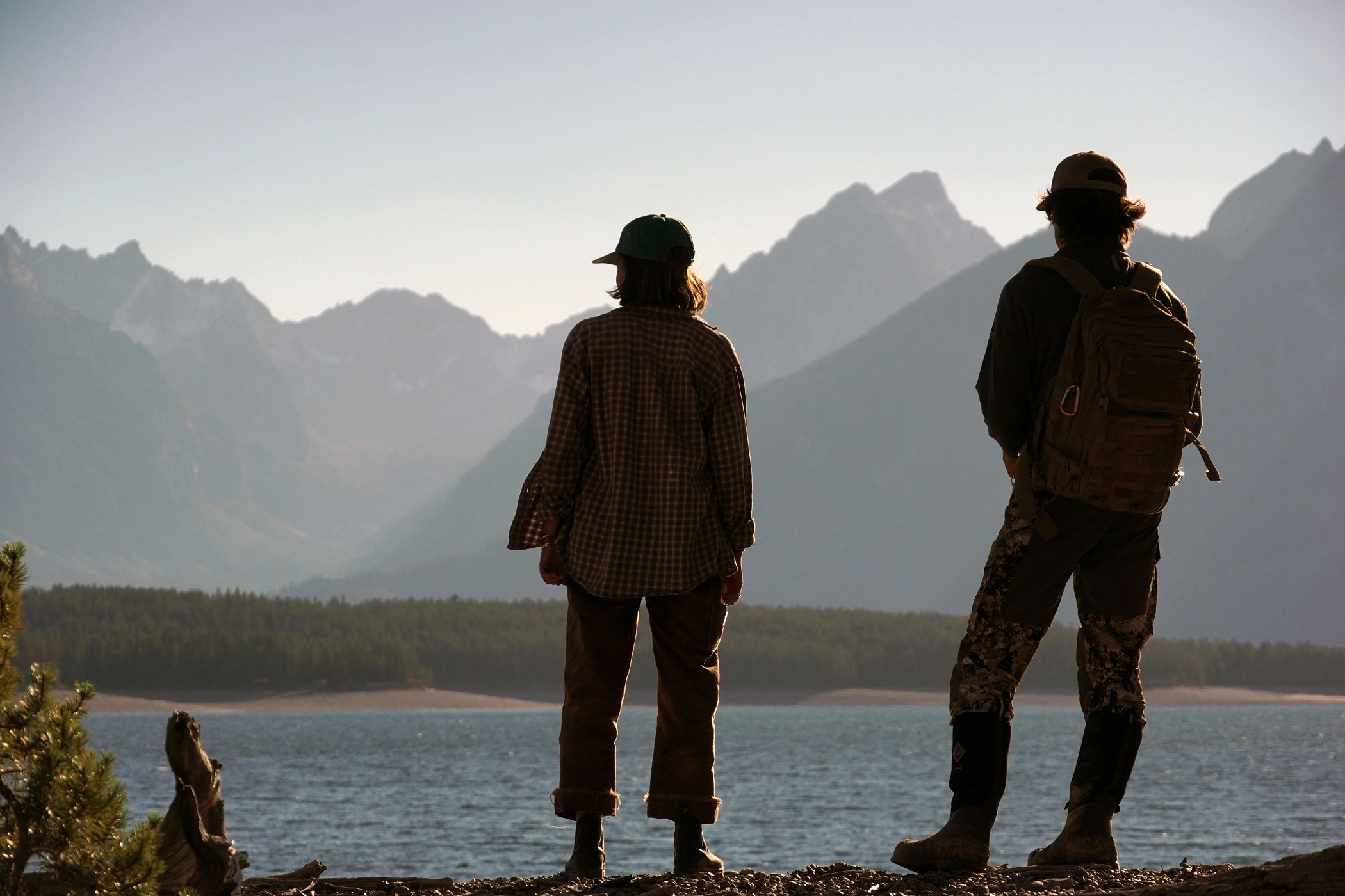 Two people looking at the Teton range across Jackson Lake