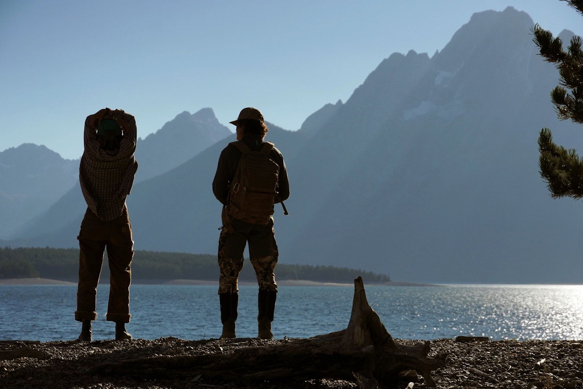Two people looking out at tetons across Jackson Lake
