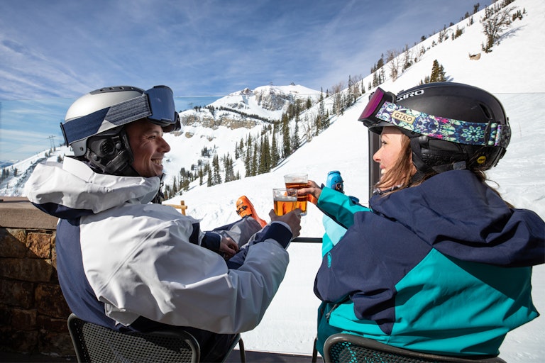 Man and woman enjoying apres drinks on the mountain