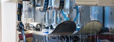Skis being waxed by a machine