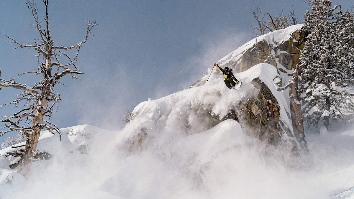 Skier doing a grab off a large cliff