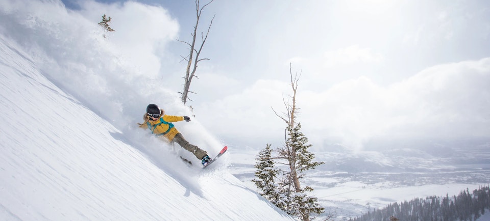 Woman snowboarding in powder