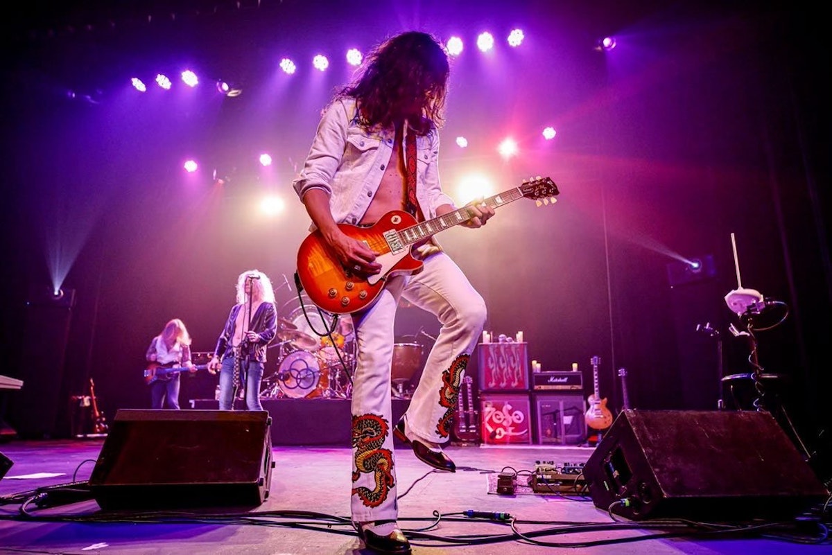 ZOSO performing on stage with guitarist front and center