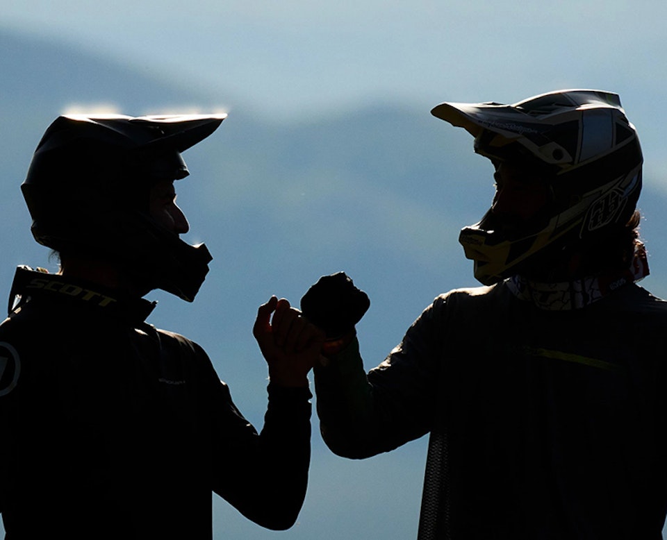 two hikers highfiving with JH Insider app opened to achievements page