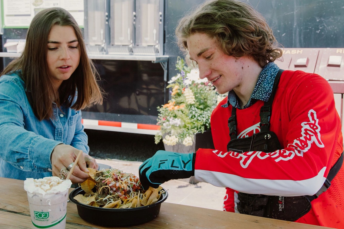 Two people sharing nachos from Tin Can Cantina
