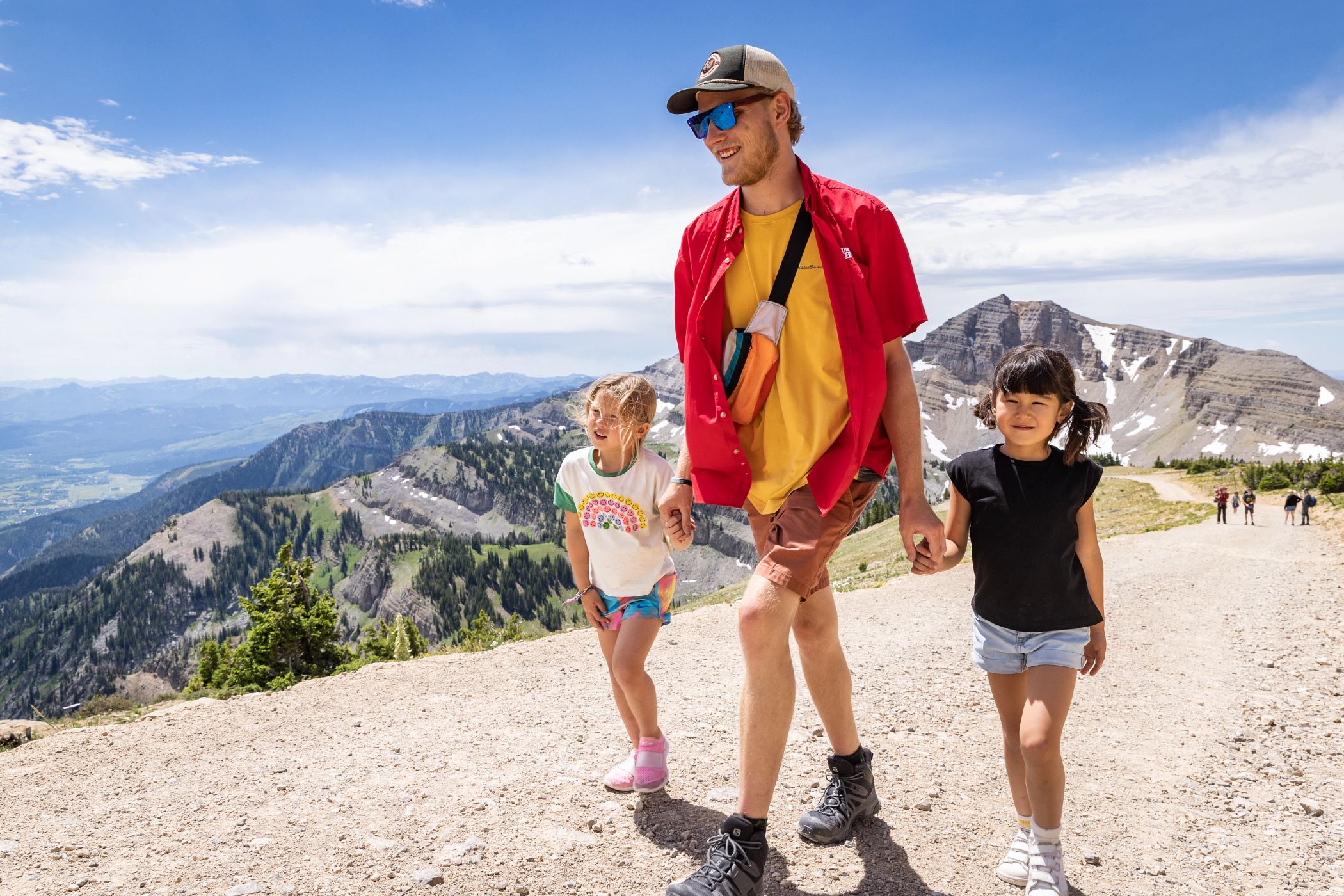 Two girls hiking with a man at the Grand Adventure Camp