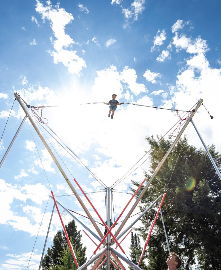 a child jumping high on the bungee trampoline